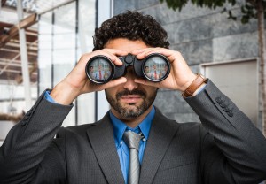 Businessman using binoculars, people portraits in the lens